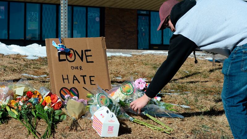 Elijah Newcomb of Colorado Springs lays flowers near a gay nightclub in Colorado Springs,...