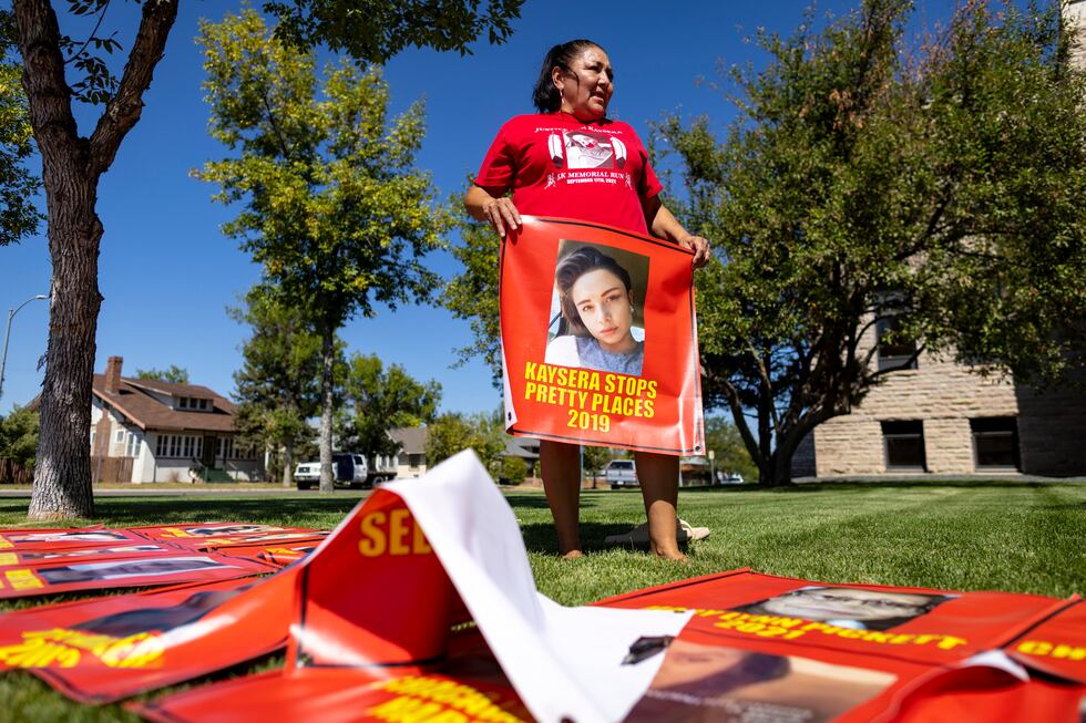 Melissa Lonebear holds a banner with a picture of Kaysera Stops Pretty Places on it during a...