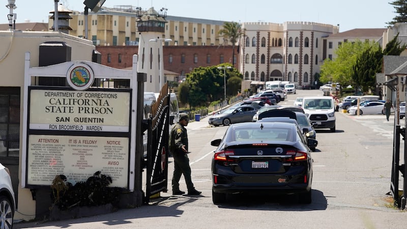 FILE - A guard checks vehicles entering the main gate at San Quentin State Prison on April 12,...