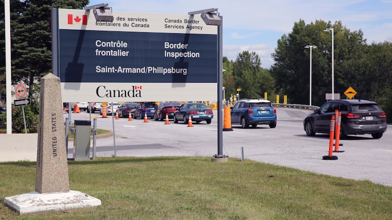 Cars pass a monument marking the border between the United States and Canada on Wednesday,...